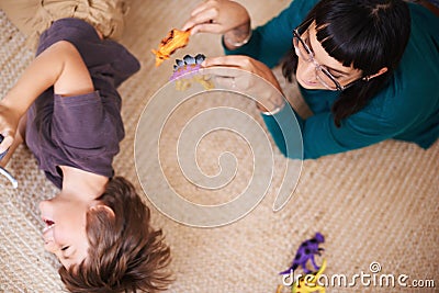 Woman, child and toy with dinosaur, floor and play for joy or fun at family home or house. Mother, kid and bedroom with Stock Photo