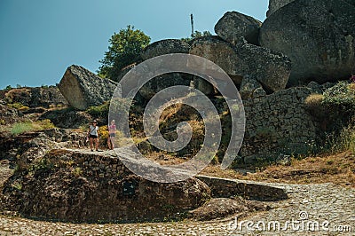 Woman and child walking by a path with rocks in Monsanto Editorial Stock Photo