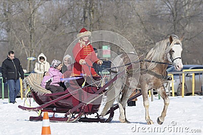 Woman and children having a horse drawn sleigh ride at the sunny winter park Editorial Stock Photo