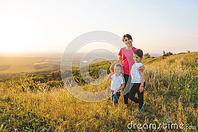 Woman with children on sunny hill Stock Photo