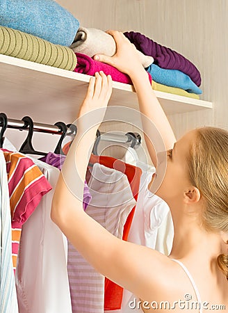 Woman chooses clothes in the wardrobe closet at home Stock Photo