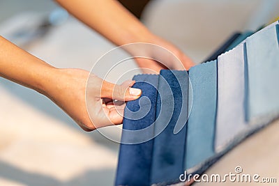 The woman chooses the fabric on the sofa. Textile industry background. Tissue catalog Stock Photo