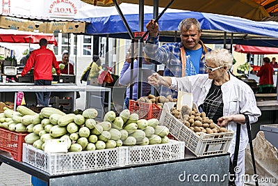A woman chooses fruits and vegetables on the market Editorial Stock Photo
