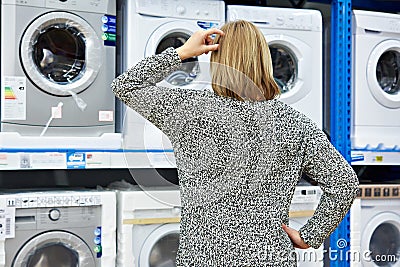 Woman chooses washing machine in shop of home appliances Stock Photo