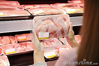 Woman choosing packed chicken meat Stock Photo