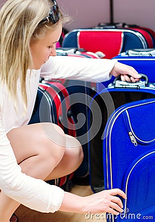 Woman choosing travel suitcase. Stock Photo