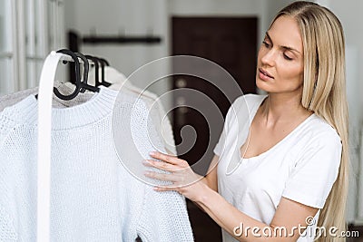 Woman choosing wool knitted sweater in pastel colours Stock Photo