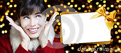 Woman with christmas gift card in golden lights Stock Photo