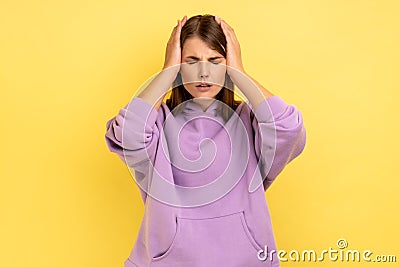 Woman clasping hands over sore head, frowning from acute pain suffering unbearable migraine. Stock Photo