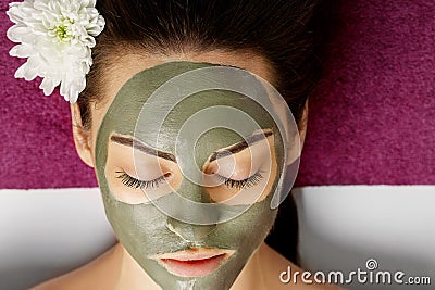 Woman with clay facial mask in beauty spa. Skincare. Beauty Concept. Facial treatment. Cosmetology. Body care girl`s Stock Photo