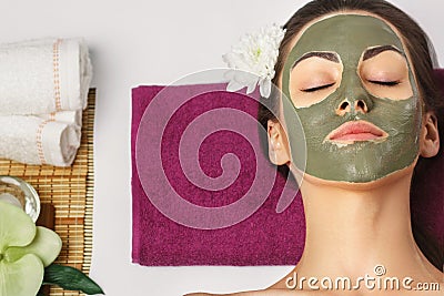 Woman with clay facial mask in beauty spa. Skincare. Beauty Concept. Close-up portrait of beautiful girl with facial mask.Facial Stock Photo