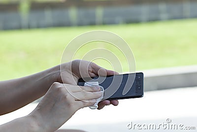 Woman clean phone in napkin Stock Photo