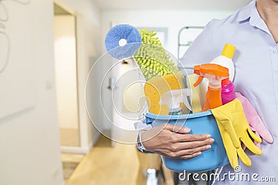 Woman with cleaning equipment ready to clean house Stock Photo