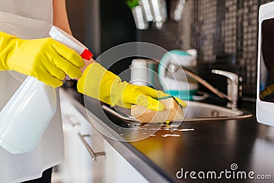 Woman cleaning kitchen cabinets with sponge and spray cleaner Stock Photo