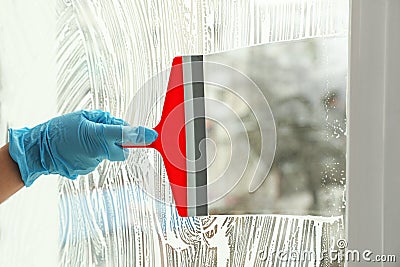 Woman cleaning window with squeegee, closeup Stock Photo