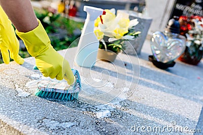 A woman cleans the grave. Stock Photo