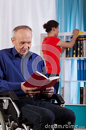 Woman cleans the house the disabled man Stock Photo