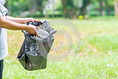 Woman cleans up by picking up plastic bottles in garden. Concept of protecting the environment, saving the world, recycling, Stock Photo