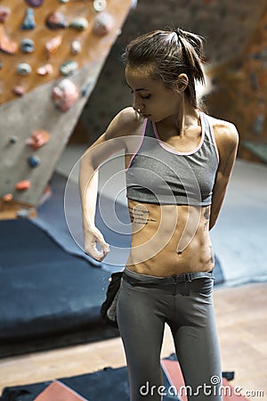 Woman climber is chalking hands with white chalk powder before climb in indoor climbing gym. woman getting ready to Stock Photo