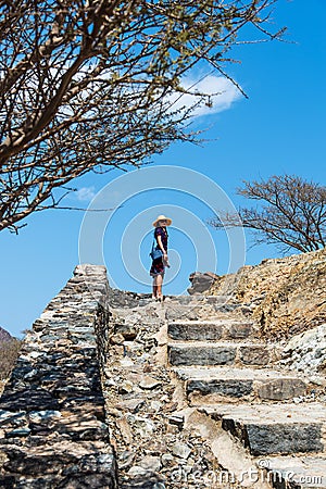 Woman climbing stairs to desert fortress Stock Photo