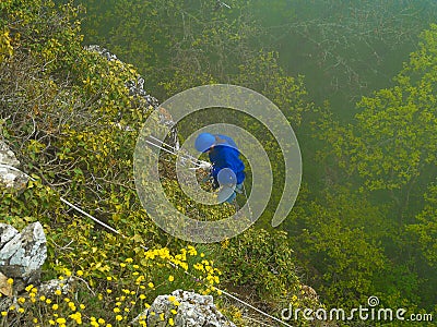 Woman climbing on steep the mountain slope Editorial Stock Photo