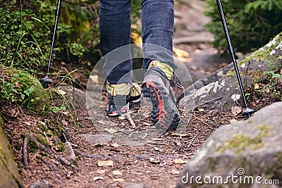 Woman climbs in Hiking boots in outdoor action. Top View of Boot on the trail. Close-up Legs In Jeans And sport trekking Stock Photo