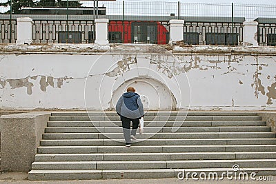 Woman climbs the steps to the train station Stock Photo