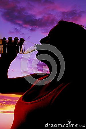 Woman close silhouette drinking water from bottle Stock Photo