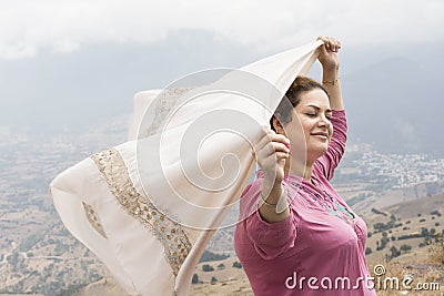 Woman with closed eyes holding a scarf in hands in natuer and en Stock Photo