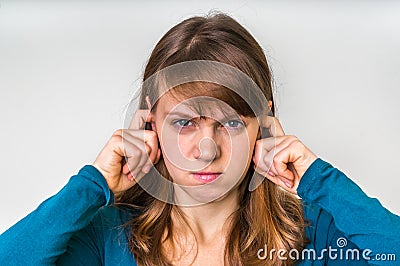 Woman closes ears with fingers to protect from loud noise Stock Photo