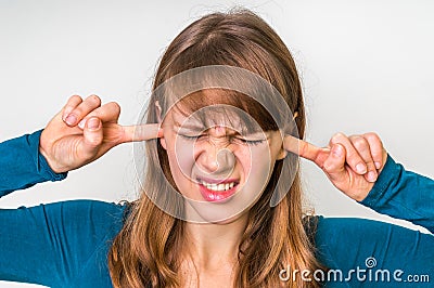 Woman closes ears with fingers to protect from loud noise Stock Photo