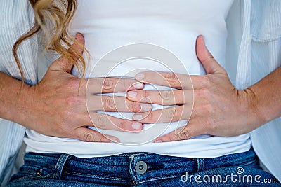 woman clutching her stomach in discomfort Stock Photo