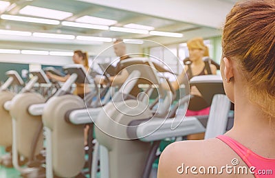 Woman coach looking people in elliptical trainer Stock Photo