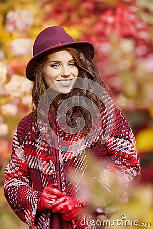 Woman in coat with hat and scarf in autumn park Stock Photo