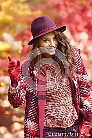 Woman in coat with hat and scarf in autumn park Stock Photo