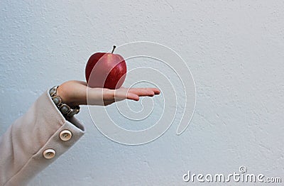 Woman in a coat holds a red tasty apple Stock Photo