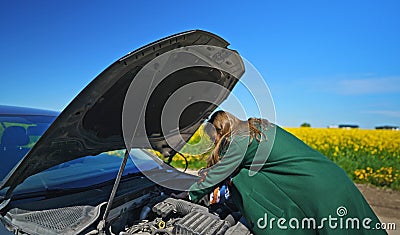 Woman in the coat opens the hood Stock Photo