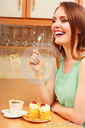 Woman with coffee eating cream cake. Gluttony. Stock Photo