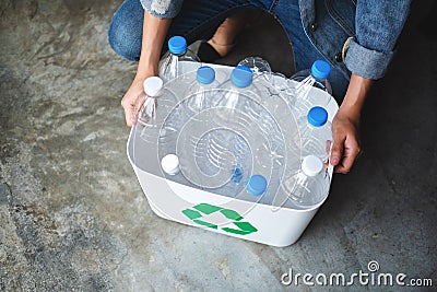 A woman collecting and separating recyclable garbage plastic bottles into a trash bin Stock Photo