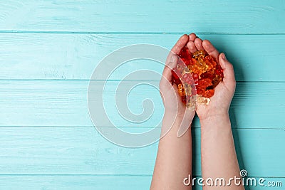 Woman with colorful jelly bears on wooden background, top view Editorial Stock Photo