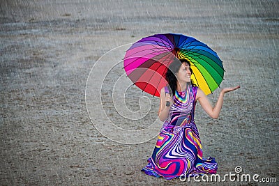 Woman with colorful umbrella under the rain Stock Photo