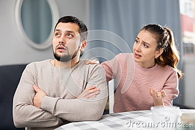 Woman comforting offended husband after spat at home Stock Photo