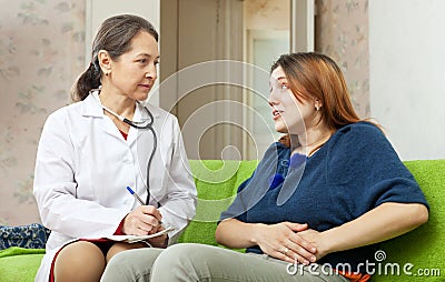 Woman complaining to doctor about abdominal pain Stock Photo