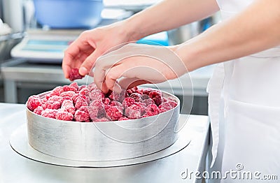 Woman confectioner making raspberry cake Stock Photo