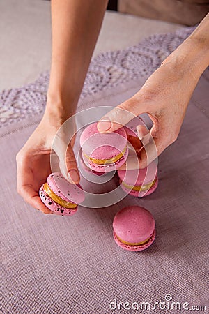 Woman confectioner showcases perfectly crafted Macaroons. Sweet mastery Stock Photo