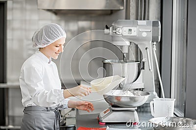 Woman confectioner working at the bakery manufacturing Stock Photo