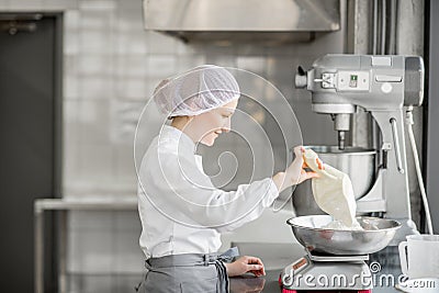 Woman confectioner working at the bakery manufacturing Stock Photo