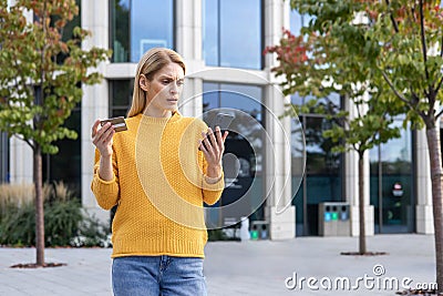 Woman confused by credit card issue while using phone outdoors Stock Photo