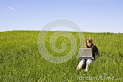 Woman connected on the grass Stock Photo