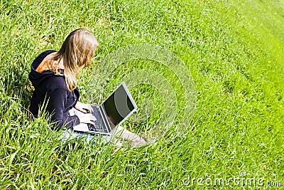 Woman connected on the grass Stock Photo